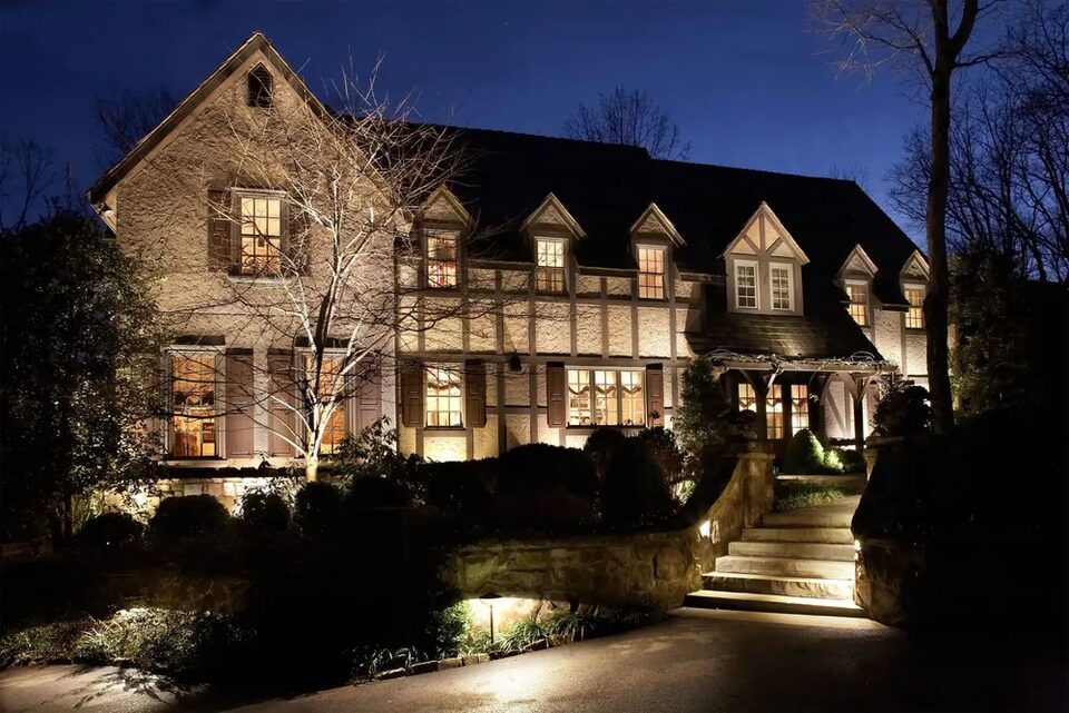 Stone house at night with landscape lighting on the facade and walkway